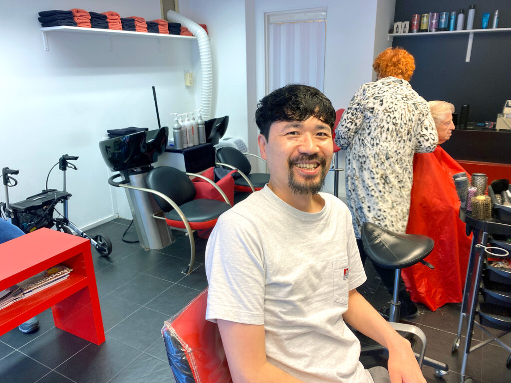 a smiling asian man at the hair salon