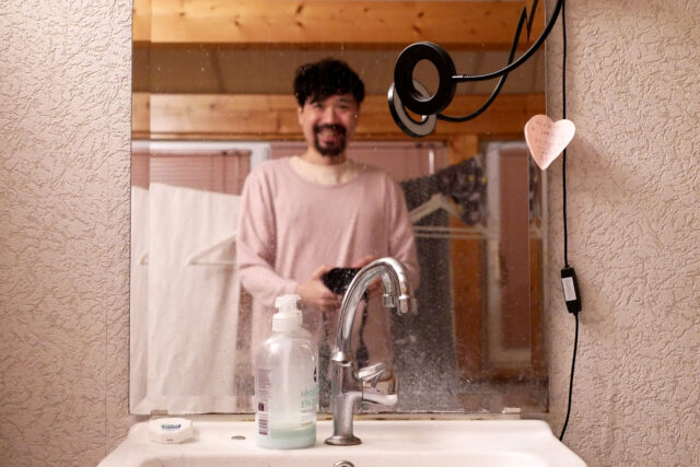 an asian man laughing on the mirror