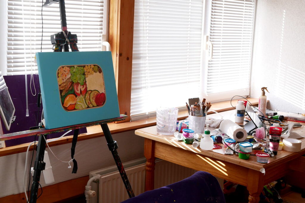 bento painting and many art materials on the messy table