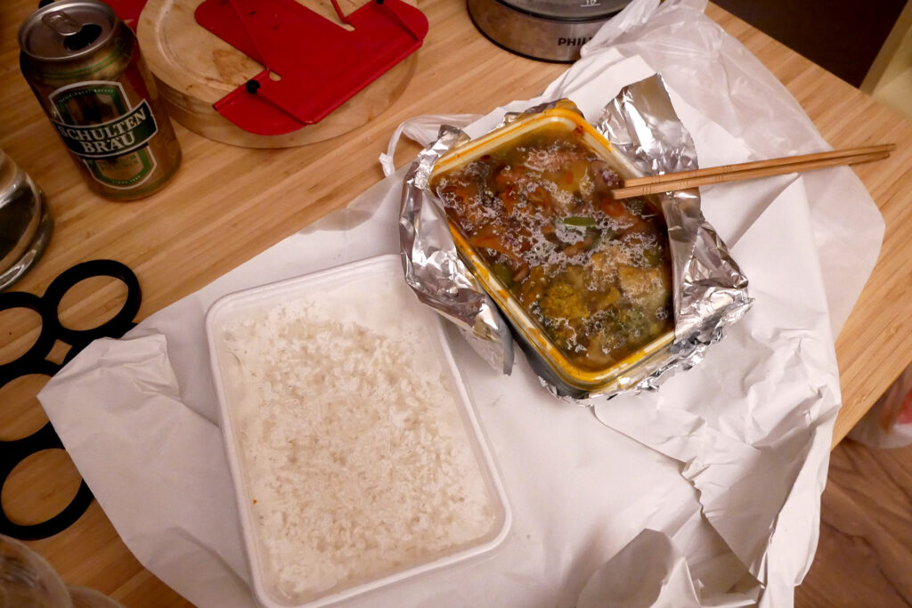 canned beer and packed Thai food for takeout on the table